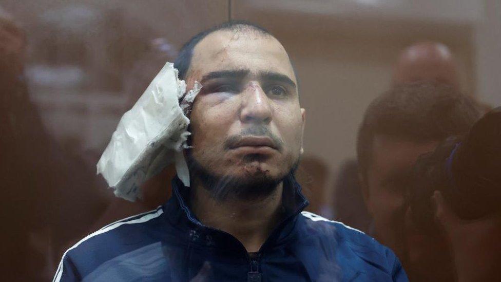 Saidakram Rajabalizoda, a suspect in the shooting attack at the Crocus City Hall concert venue, sits behind a glass wall of an enclosure for defendants at the Basmanny district court in Moscow, Russia March 24, 2024