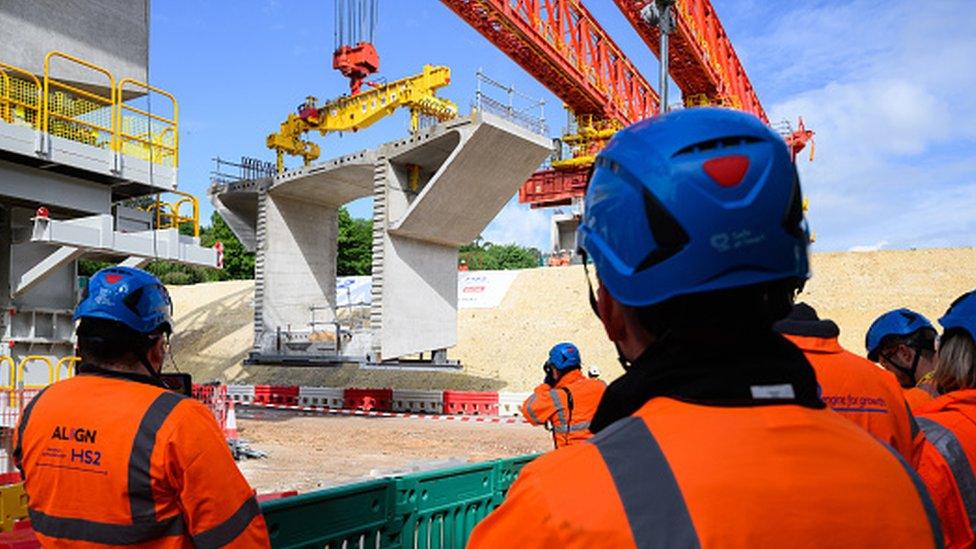 Construction workers look on at a project