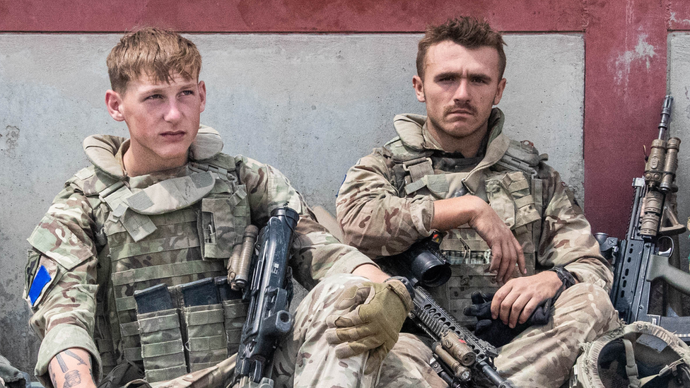 Two soldiers taking a break sat down