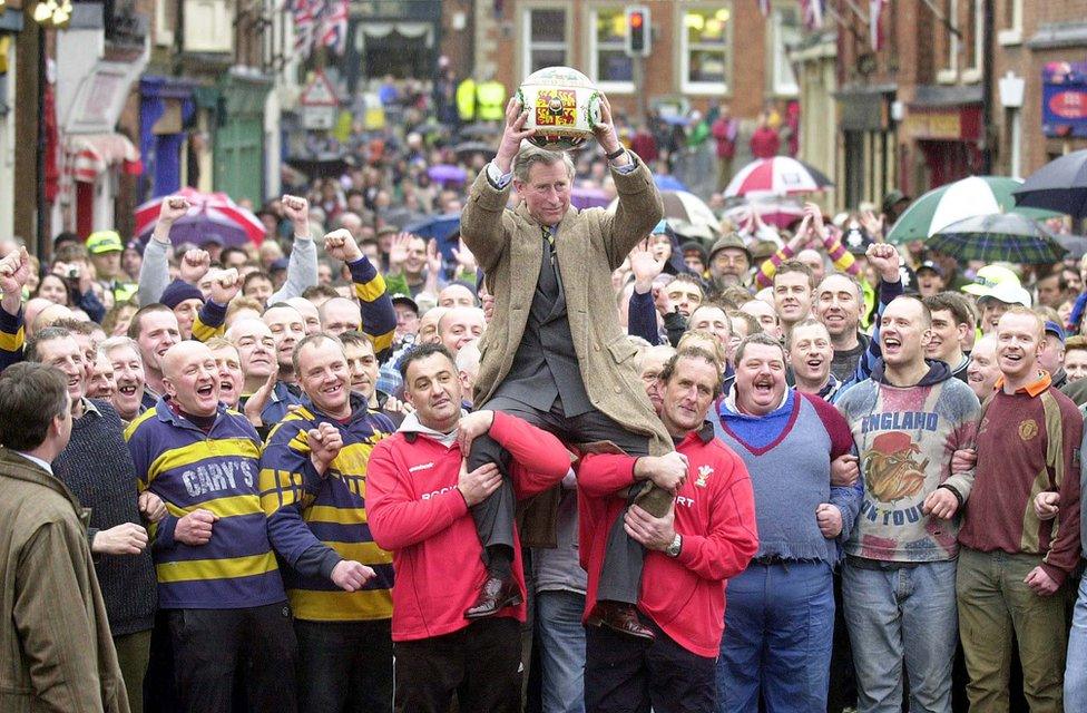 Prince Charles being lifted up holding the ceremonial ball before starting the ancient Royal Shrovetide Football game, in Ashbourne, Derbyshire