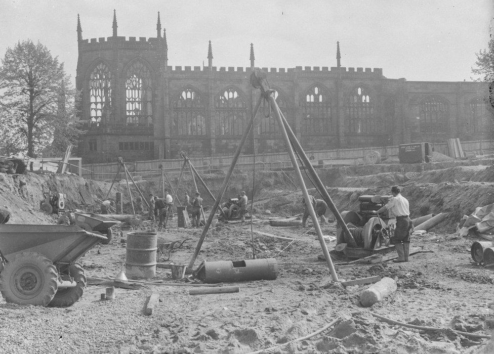 Workmen constructing concrete piles