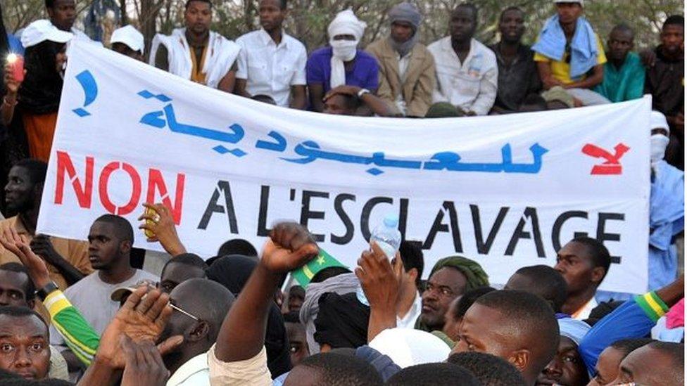 People hold a banner reading 'No to slavery' during a demonstration against discrimination in Nouakchott on April 29, 2015.