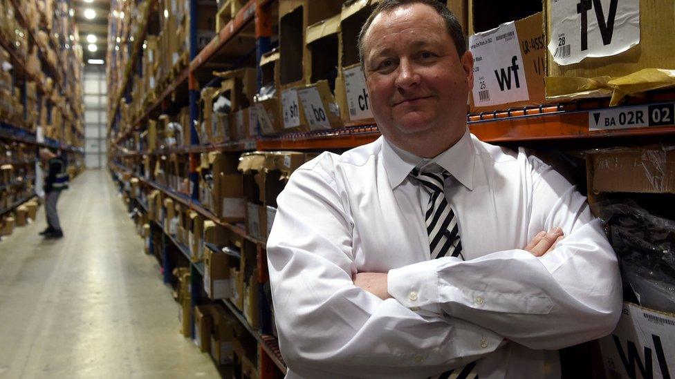 Mike Ashley standing in warehouse aisle