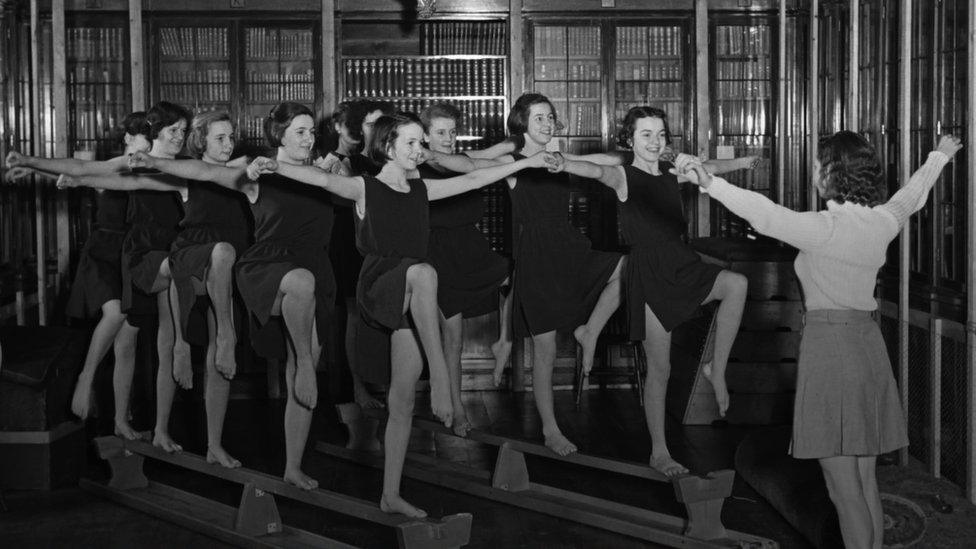 Black and white photo showing school girls exercising