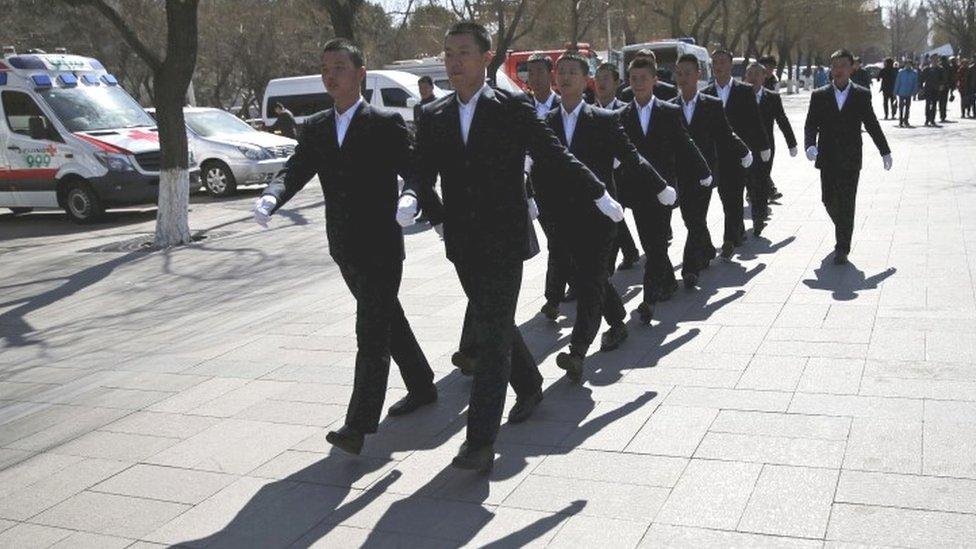 Security personnel make their way nearby the Great Hall of the People where the National People's Congress is being held in Beijing (11 March 2016)