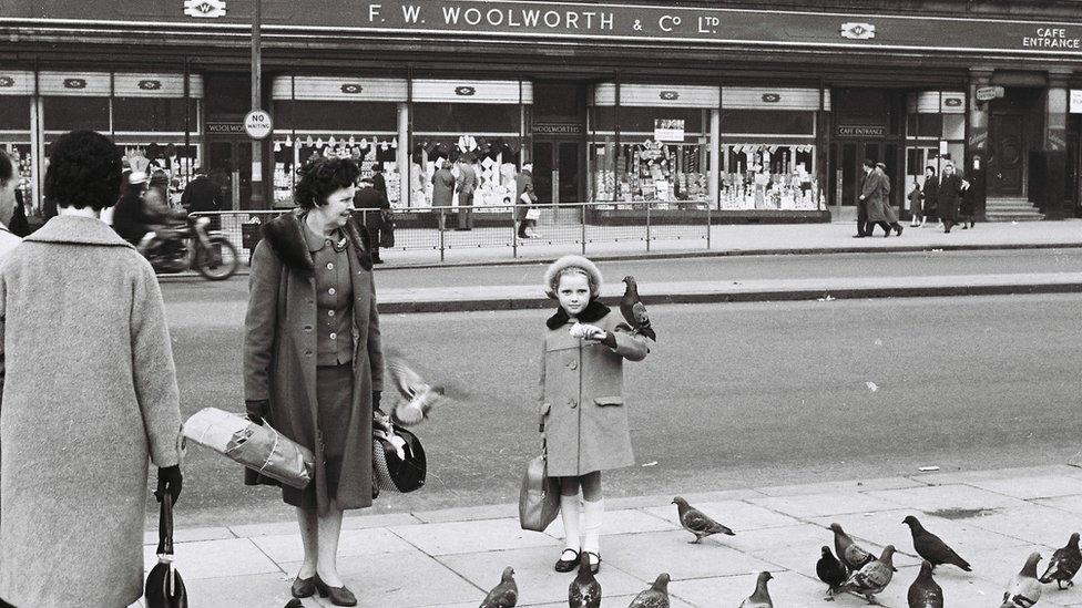 Girl poses with a pigeon on her elbow