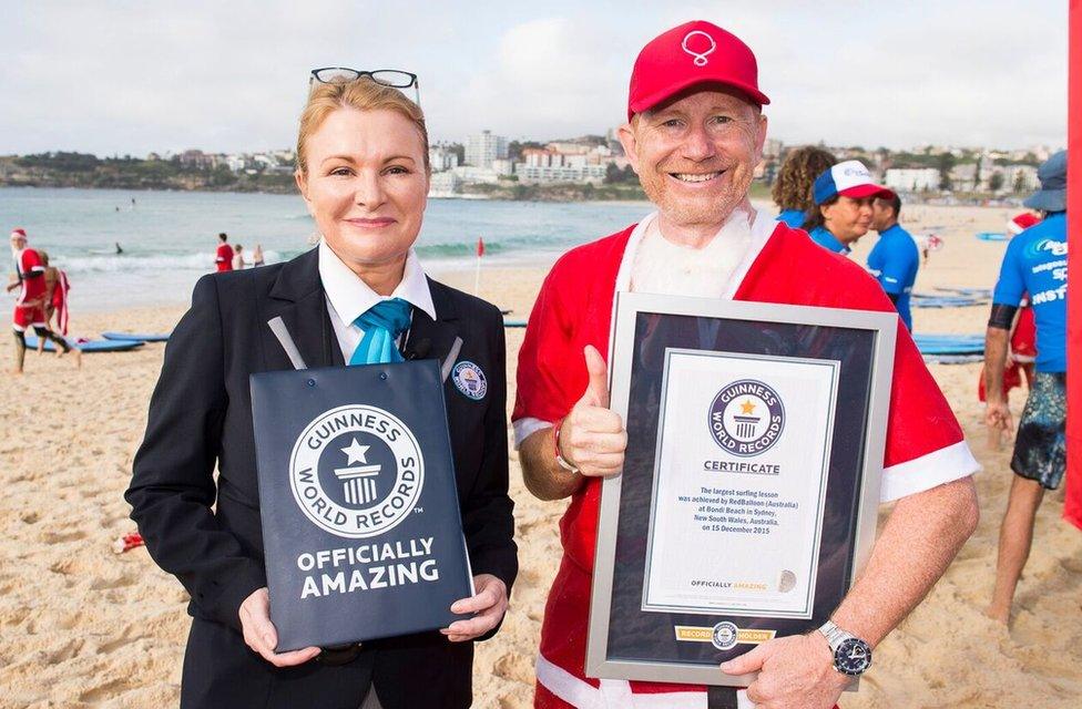 A pack of 320 surfing Santas embrace the Christmas spirit in Australia, breaking the Guinness World Record for the largest surf lesson