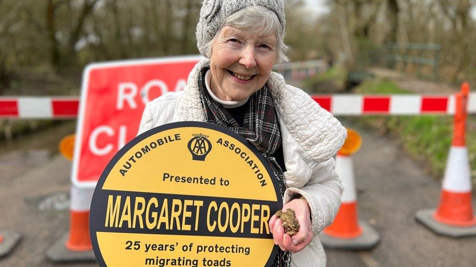 Woman with disc and toad in hand