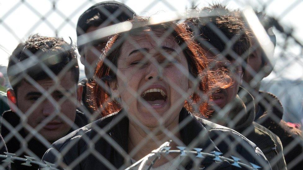 Woman shouts and cries on the Greek side of the border with Macedonia