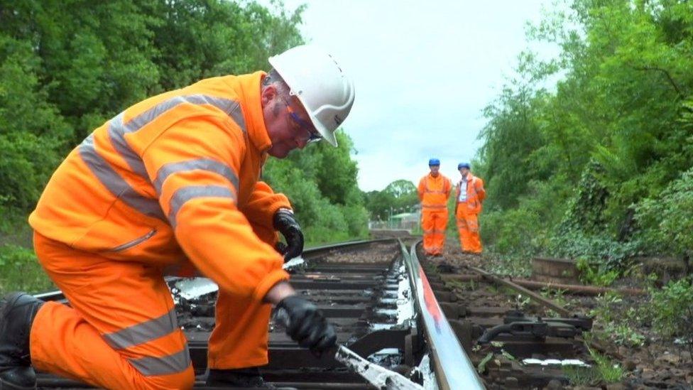 Rail worker painting the rails white