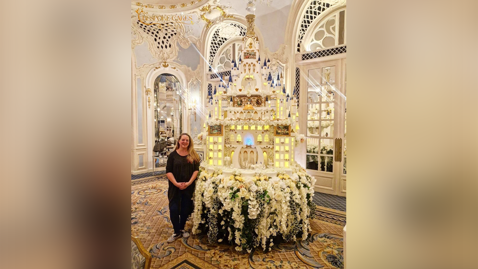 Sam Woodruff, 48, standing next to her huge cake