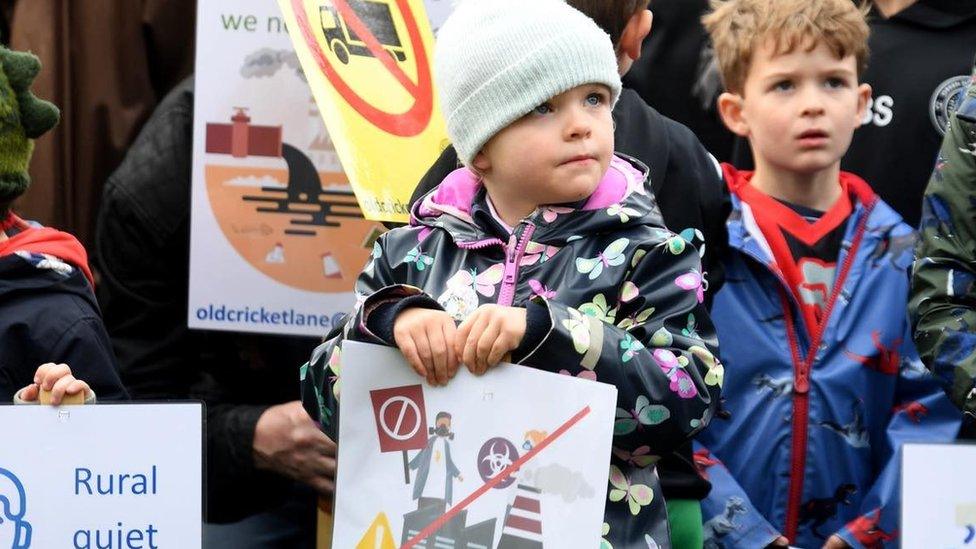 Families gathered to protest over the plans holding placards