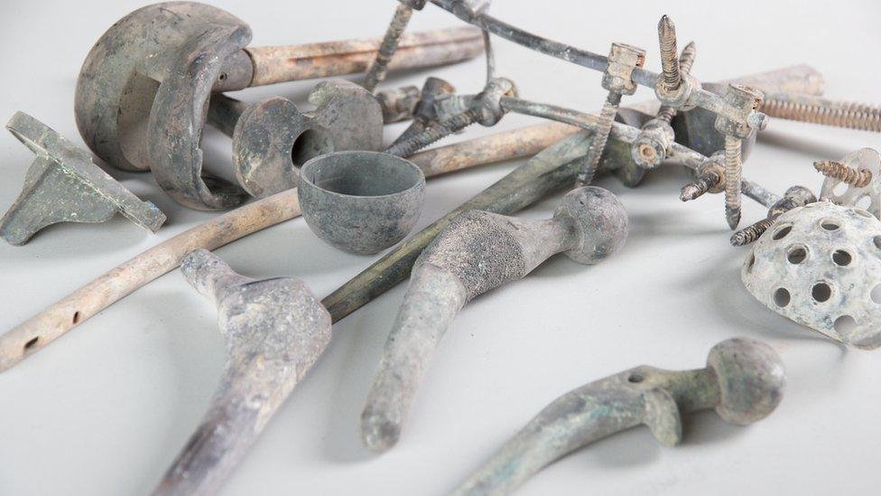 Metals remaining after cremation are removed with tongs and a magnet