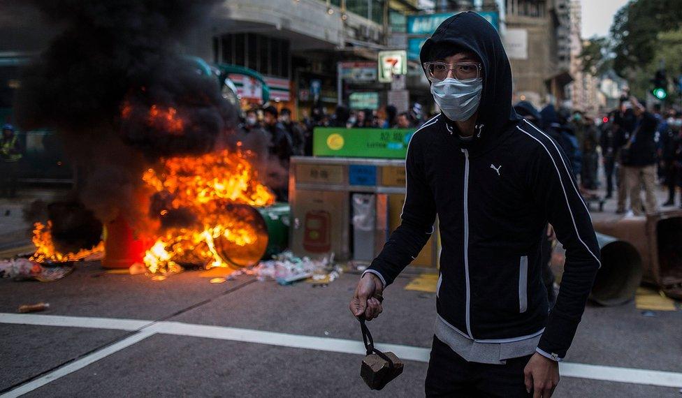 Rioter, about to throw a rock at police