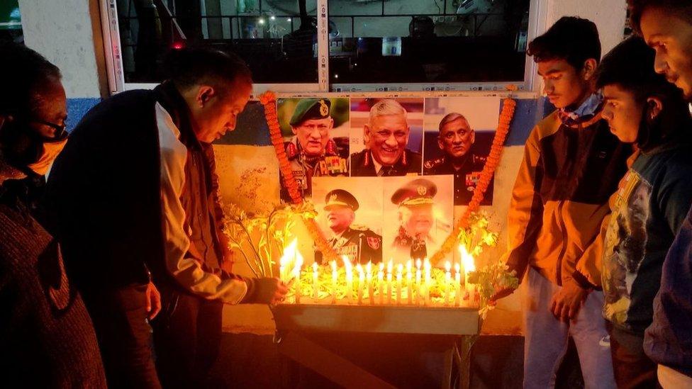 People light candles to pay their respect in front of a portrait of defence chief General Bipin Rawat in Siliguri on December 8, 2021.