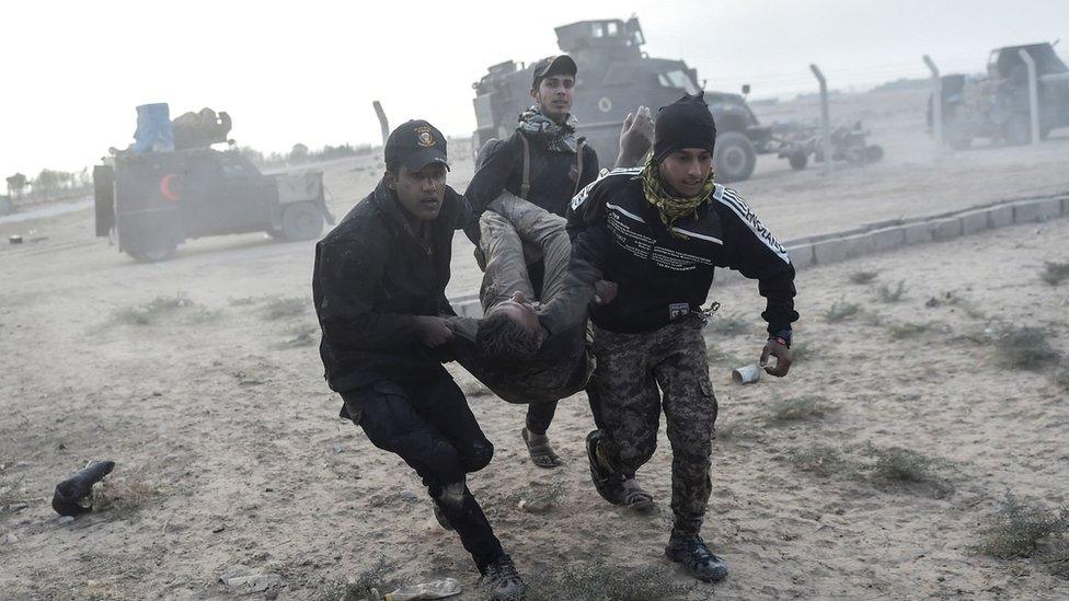 Iraqi Counter Terrorism Service (CTS) forces carry an injured comrade during clashes with IS militants near Bazwaya on 31 October 2016