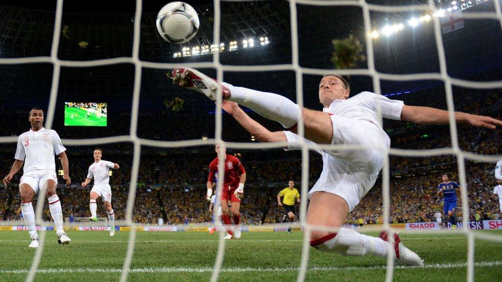 John Terry of England clears an effort from Marko Devic of Ukraine off the line on June 19, 2012