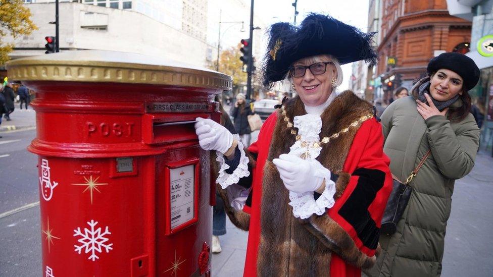 The Lord Mayor of Westminster smiling as she posts a letter in the special box.