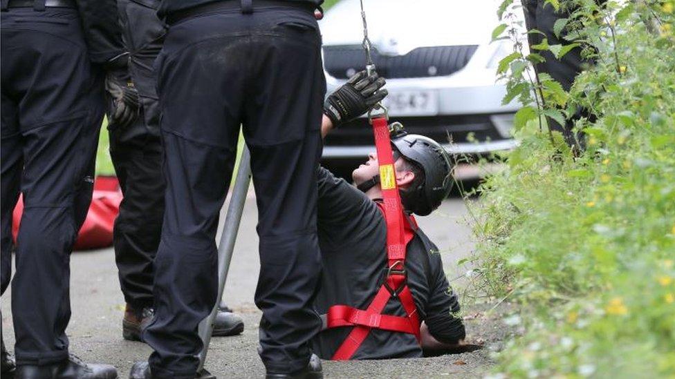 A man being lowered into a storm drain during the search for Noah Donohoe