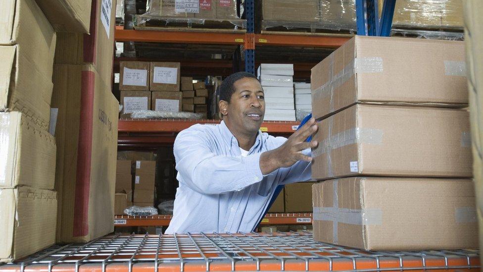 Man stacking boxes in warehouse