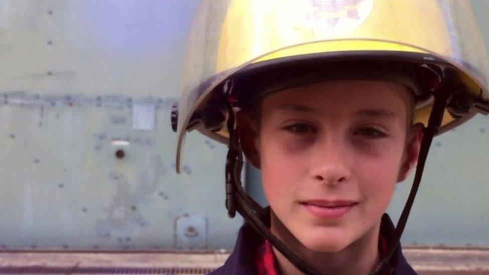 Lewis Cram wearing a firefighter helmet