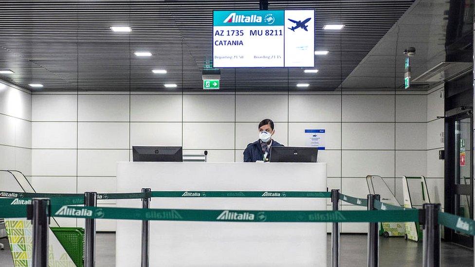 An airport worker in Italy wearing a mask