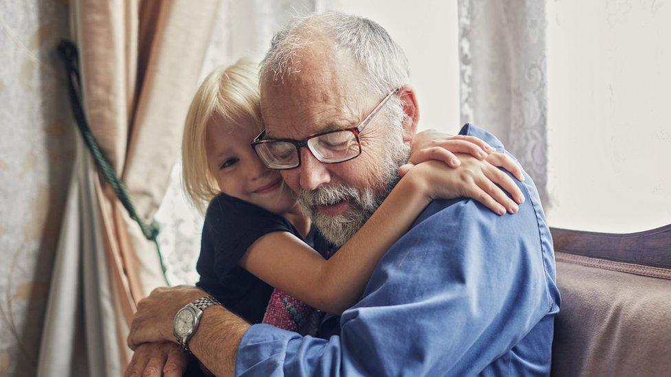 Girl hugs grandfather.