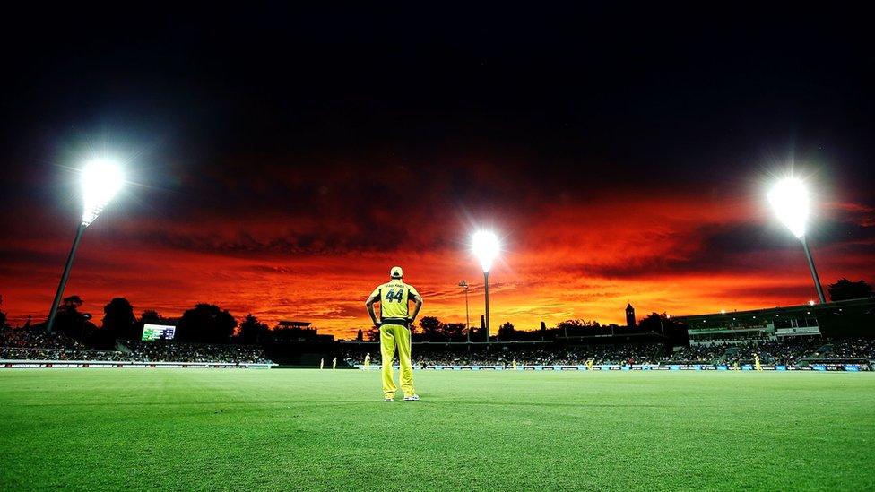 Australian cricketer James Faulkner stands in the field beneath the brilliant sky.