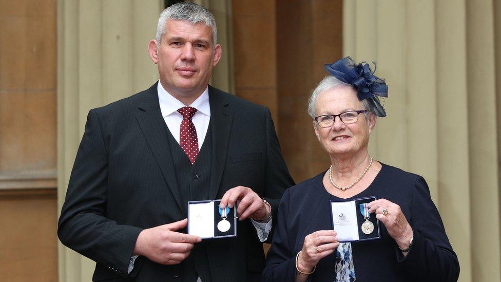 Stephen Adams and Margaret Guest with the gallantry awards outside the palace