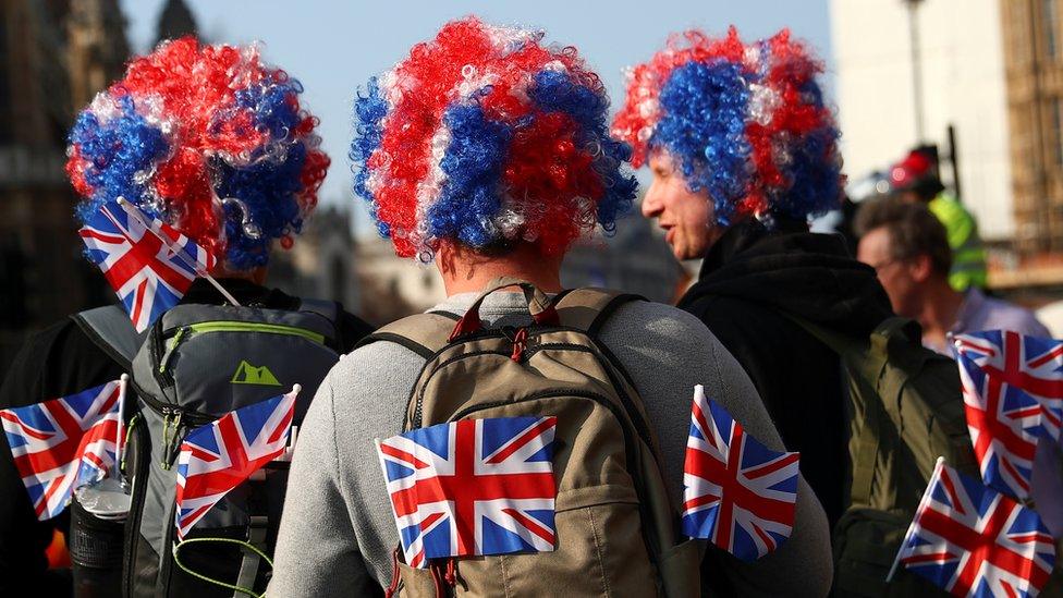 Pro-Brexit demonstrators sit outside the Houses of Parliament in London