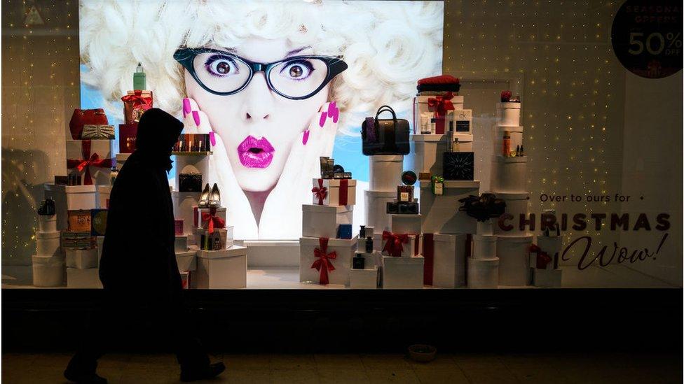 A man walks past a shop's Christmas window display