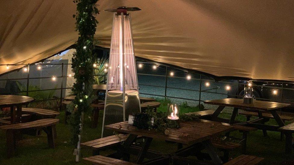 Seating and a heat lamp under a marquee