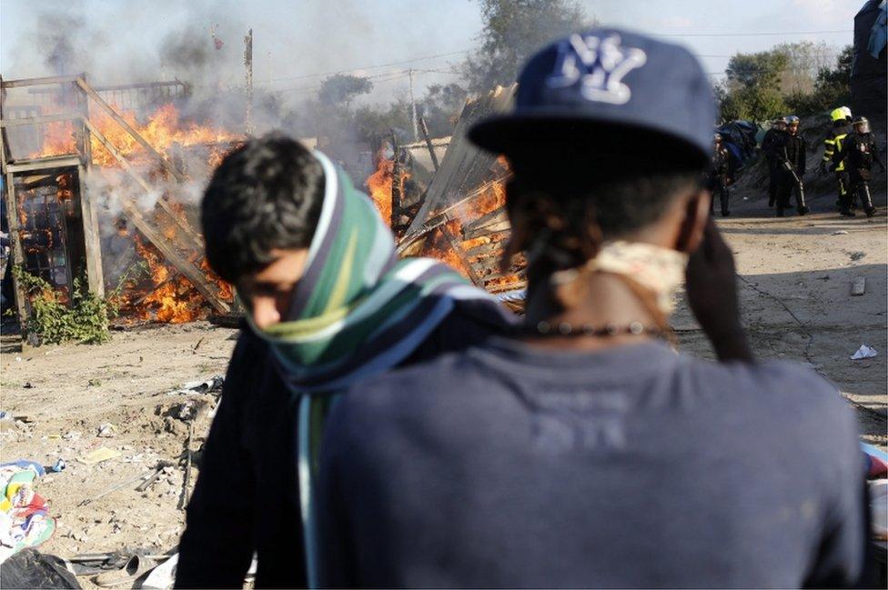 A fire burns during the dismantling of the makeshift camp known as the Jungle in Calais, France, 25 October 2016