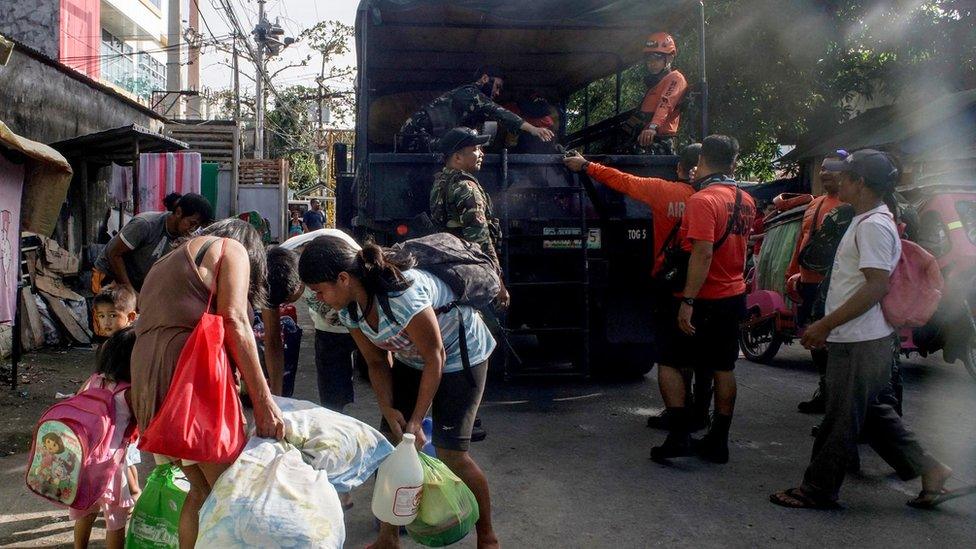 Filipino villagers board a military truck during an evacuation following an eruption of the Mayon Volcano in the town of Camalig, Albay province, Philippines