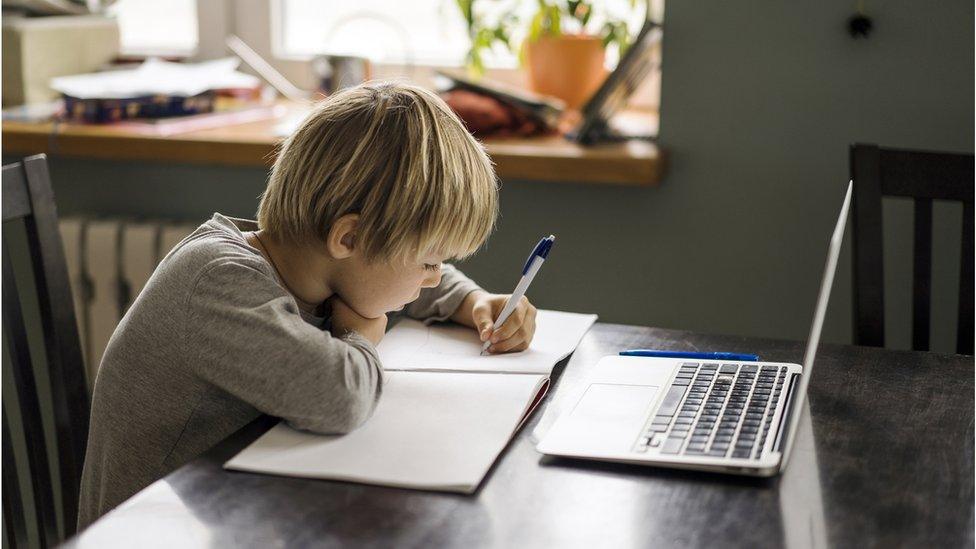 A young boy learning from home.