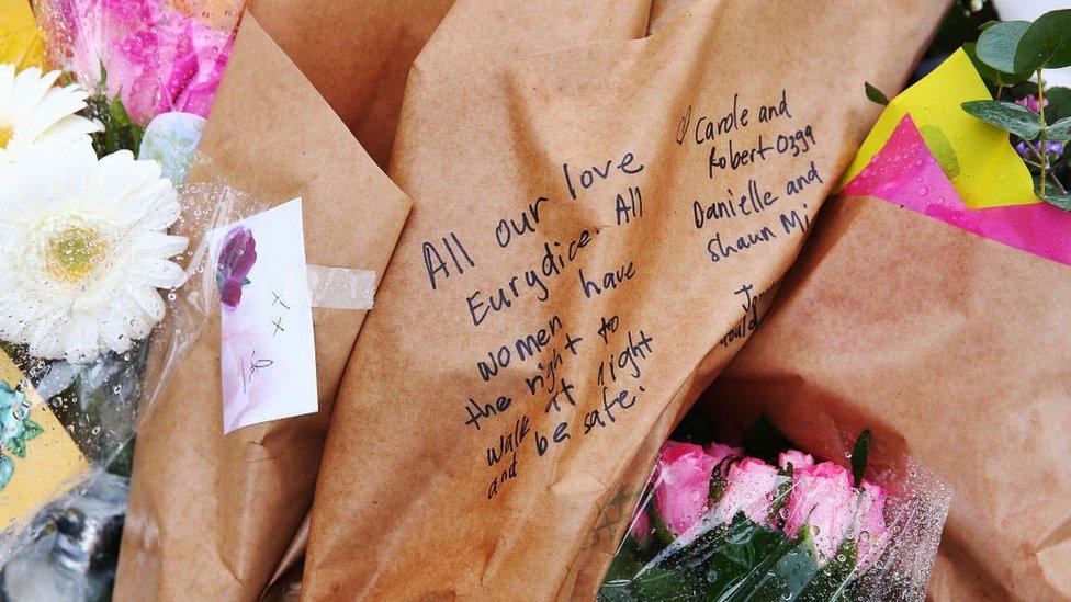 A message on a bouquet tribute reads: "All our love Eurydice. All women have the right to walk at night and be safe."