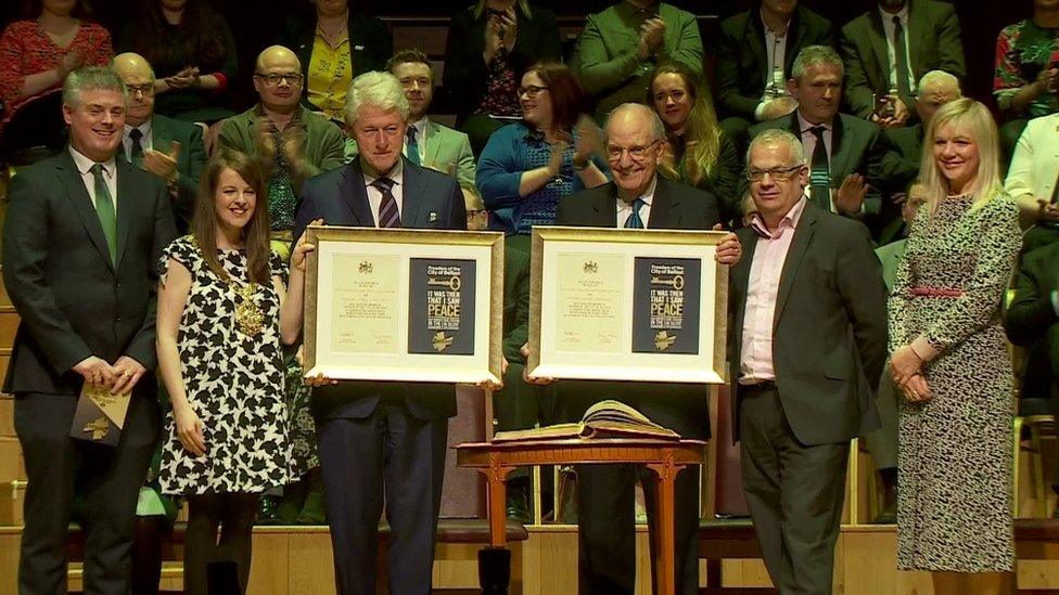 President Clinton and Senator Mitchell holding their certificates granting them Freedom of the City of Belfast