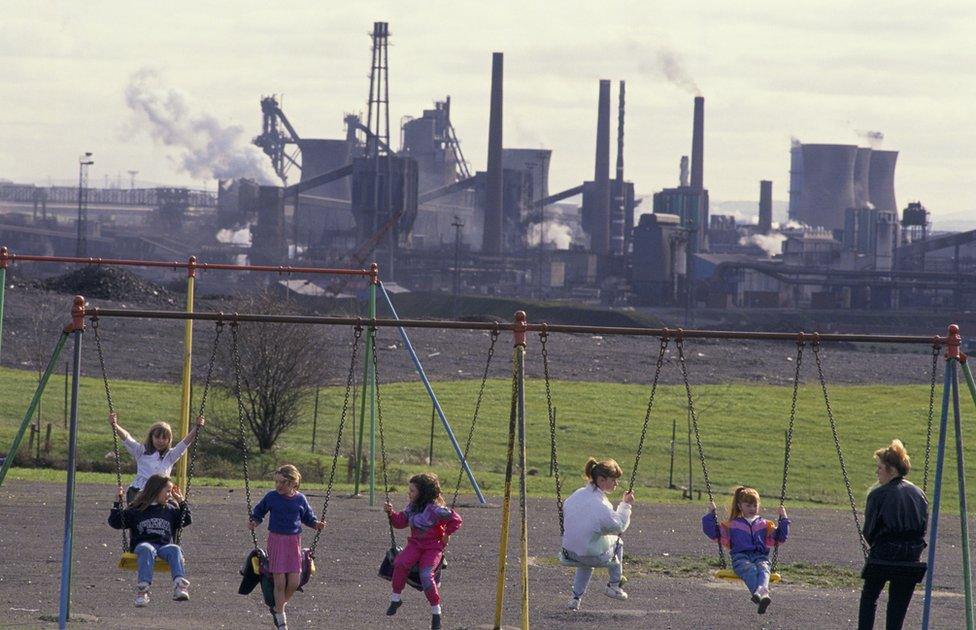 Children on swings in front of Ravenscraig steelworks in early 1990s