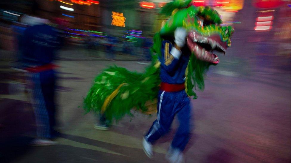 A man performs a dragon dance on the grounds of a Chinese Buddhist temple in Latha township, Yangon"s Chinatown district on February 7, 2016