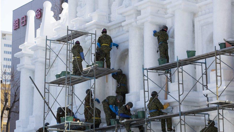 Final touches on snow sculptures resembling the "ruins of St Paul in Macao"