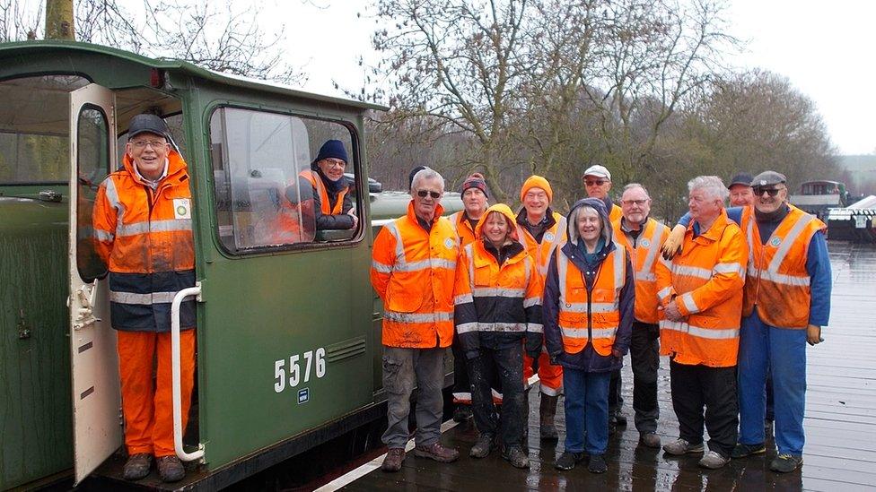 Volunteers stood with diesel shunter at heritage railway