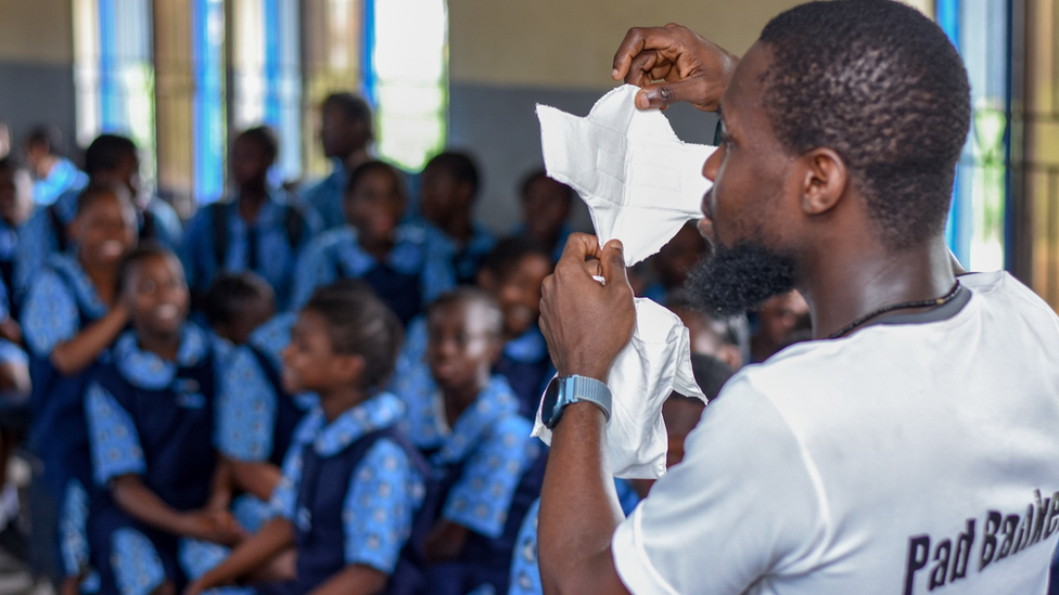 Ibrahim holding up a sanitary pad