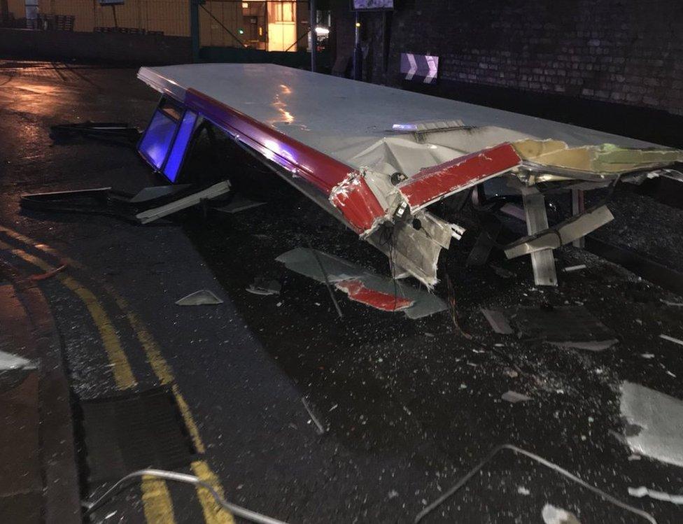 The bus's roof can be seen lying in the road