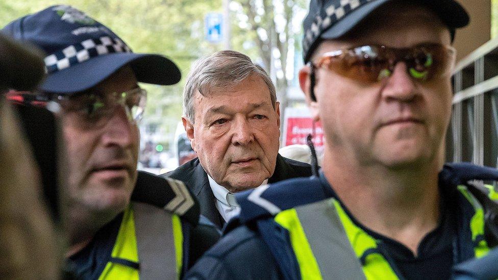 Cardinal George Pell walks towards his trial in Melbourne in 2017