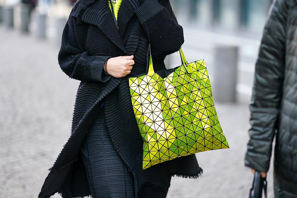 A guest with a yellow neon Bao Boa Issey Miyake handbag during Paris Fashion Week in 2020