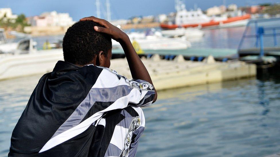 A survivor of the shipwreck of immigrants off the Italian coast looks out over the water of Lampedusa on October 8, 2013