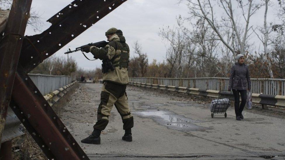 A Russia-backed rebel stands guard on a newly reconstructed bridge which connects rebel- and government-controlled territory in Stanytsia Luhanska, eastern Ukraine (27 October 2015)