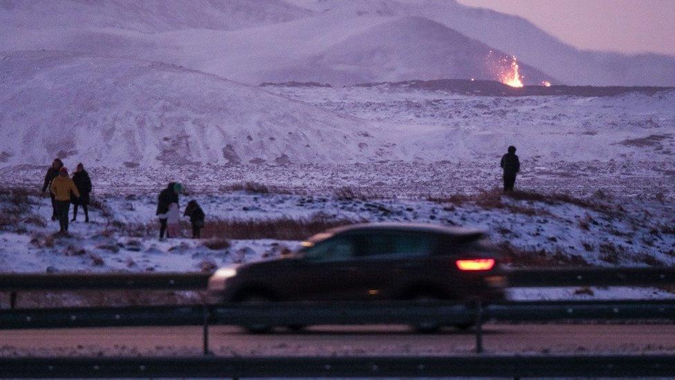 Onlookers gather to watch the lava flow after a volcanic eruption near the town of Grindavik, Reykjanes peninsula, Iceland, 19 December 2023. The start of a volcanic eruption was announced by Iceland's Meteorological Office on 18 December night after weeks of intense earthquake activity in the area.