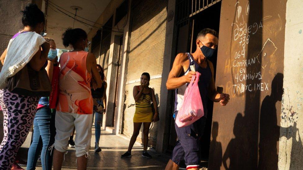 A state run bodega in Havana has a line of people wanting to enter as the sun rises. Across Cuba, people are experiencing major food shortages. April 2022.