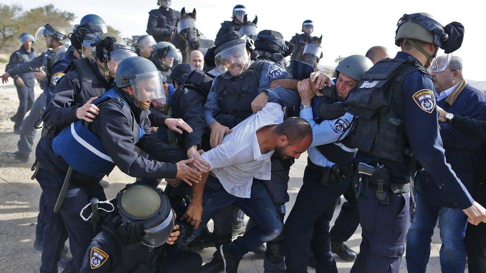 Israeli policemen detain a Bedouin man during a confrontation over home demolitions in the Bedouin village of Umm al-Hiran (18 January 2017)